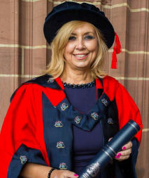 Image of Michelle Laing in red PhD robe and hat