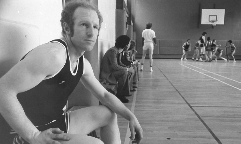 A black and white photo of Frank in a sports hall.