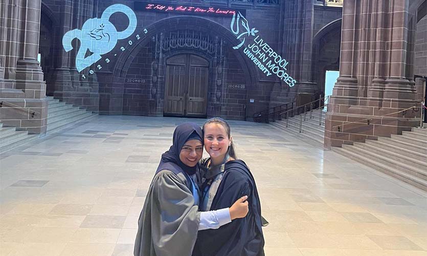 Izzy working at LJMU graduation as part of the corporate communications team with fellow international graduate Samina.