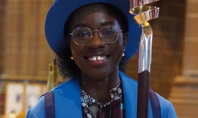Marie wearing a cap and gown at a graduation ceremony in 2022