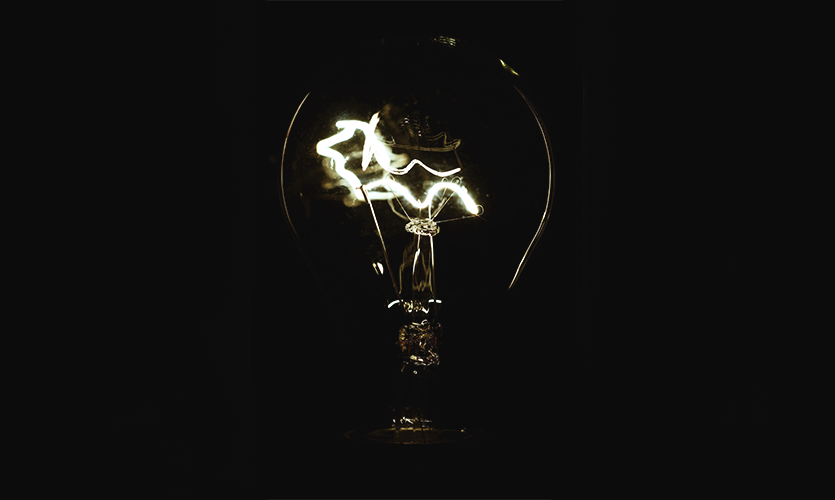 Light bulb with bright filament on a black background