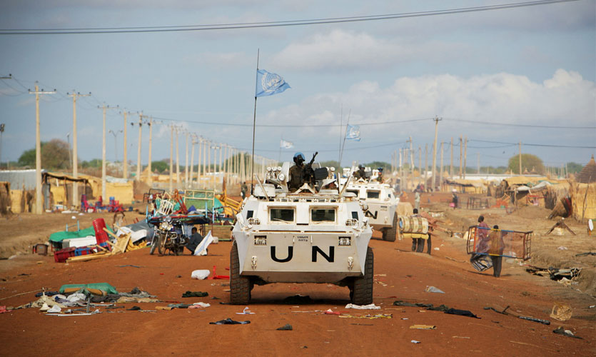 UN vehicles patrol a street lined with looted items awaiting collection