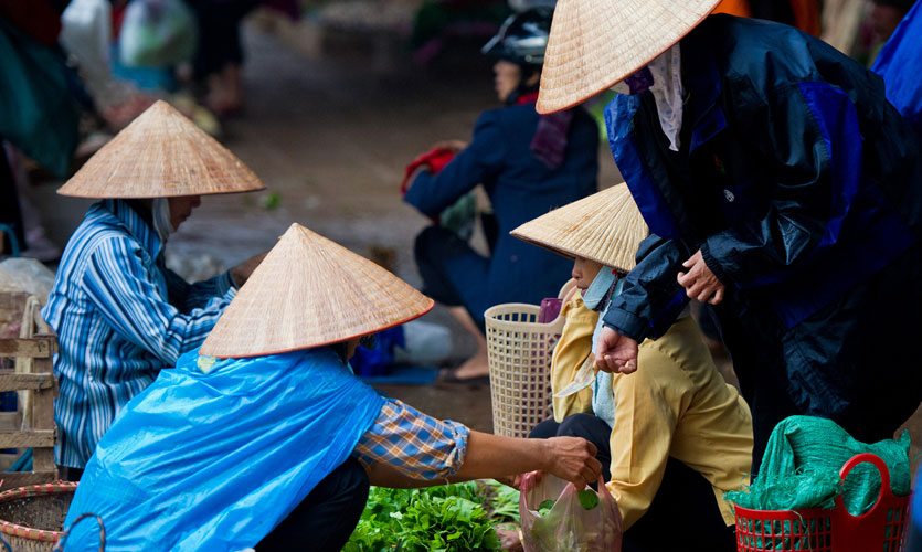 People shopping for fresh vegetables at a market in Vietnam