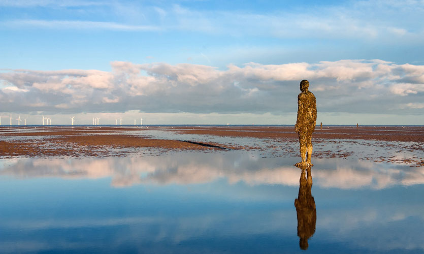 A figure from Antony Gormley's Another Place at Crosby Beach