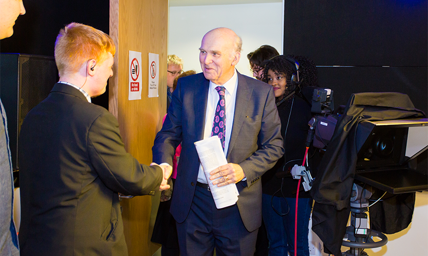 Sir Vince Cable shaking hands with an LJMU student