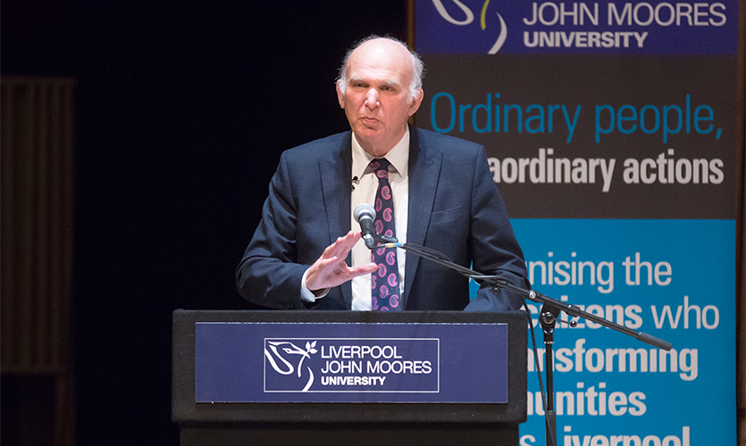 Sir Vince Cable standing at a podium delivering his Roscoe Lecture at the Philharmonic