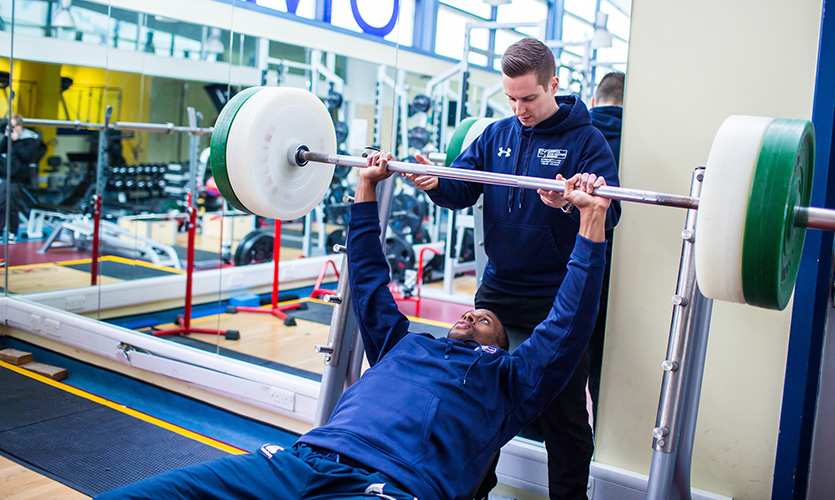 Head Strength and Conditioning Coach, Carl, supports weightlifter