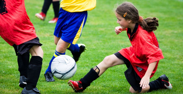 Image of young girls playing football