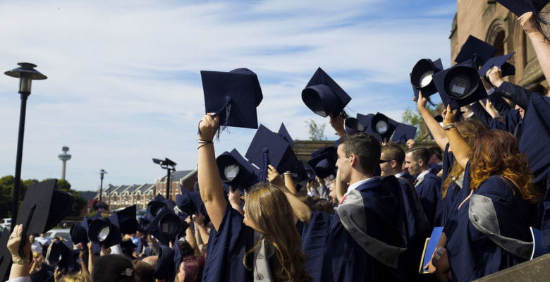 Image of graduates throwing mortar boards in the air