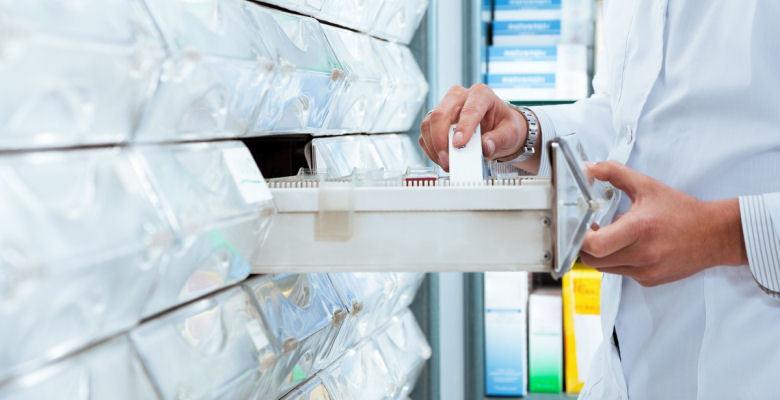 Image of pharmacist pulling out a draw full of medicines