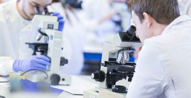 Image of LJMU students looking through microscopes in LJMU science lab