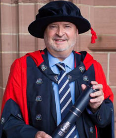 Image of Lawrence Burke in his PhD cap and gown