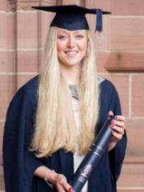 Image of Becky Nesbitt wearing cap and gown holding degree scroll