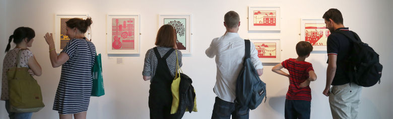 Image of people looking at art on the wall