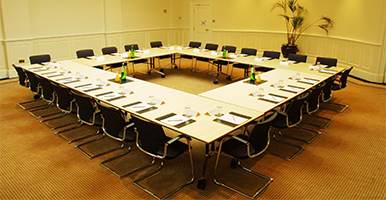 Image of a boardroom with a square table set out ready for a meeting