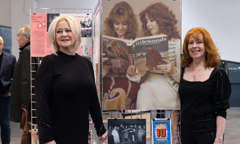 Two women stood either side of an old photograph of themselves taken wen working for Littlewoods on display at the Museum of Liverpool John Moores University