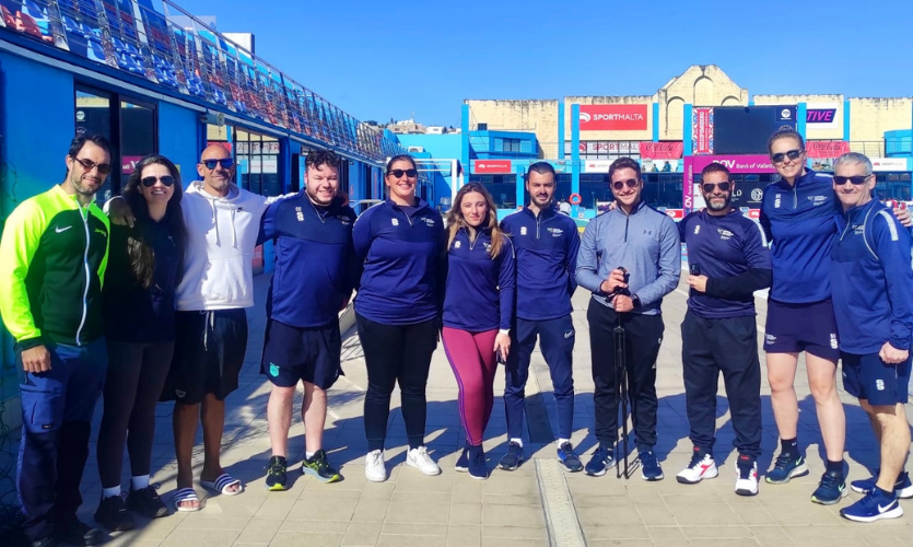 A group of 11 academics stood at an outdoor swimming training facility in Malta