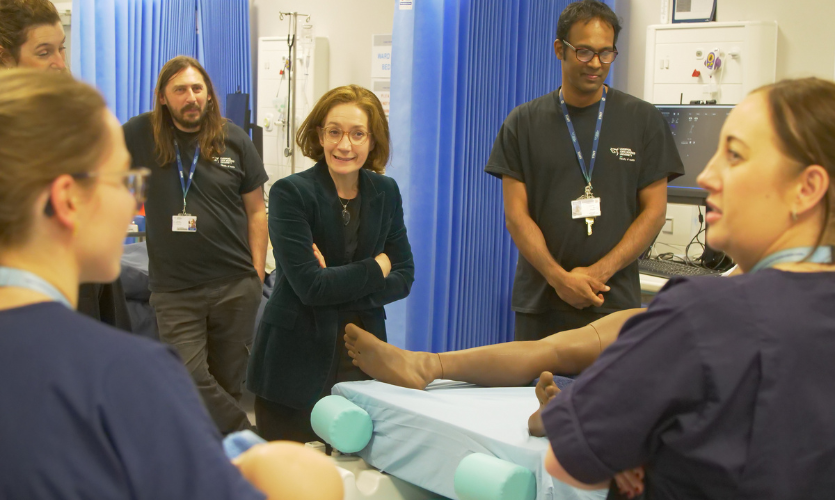 Vivienne Stern of Universities UK smiling as she talks to LJMU students and staff in a midwifery ward simulation suite 