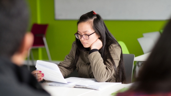 Image of student in library with book