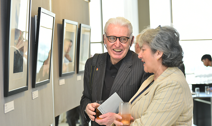 Mike McCartney discussing one of his images with an exhibition guest.