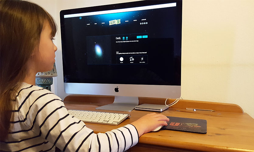Image of a young girl using the Galaxy Zoo software on a computer.