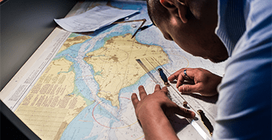 Image of a man charting a route on a map
