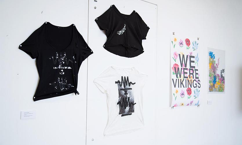 T-Shirts and paintings on one of the walls in the exhibition space