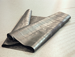 Roll of graphite paper laid out on a floor.