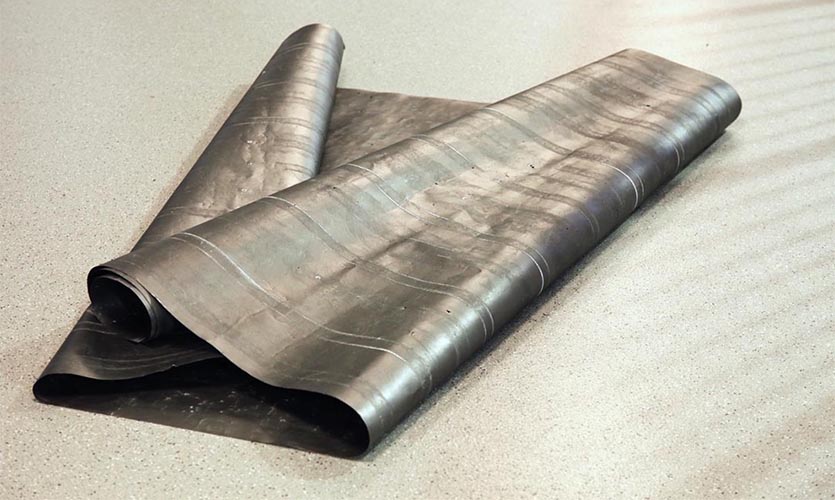 Image of graphite paper folded up on a floor