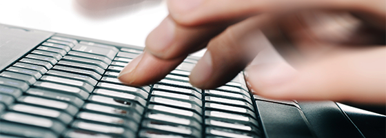 Close up shot of hands typing on a laptop